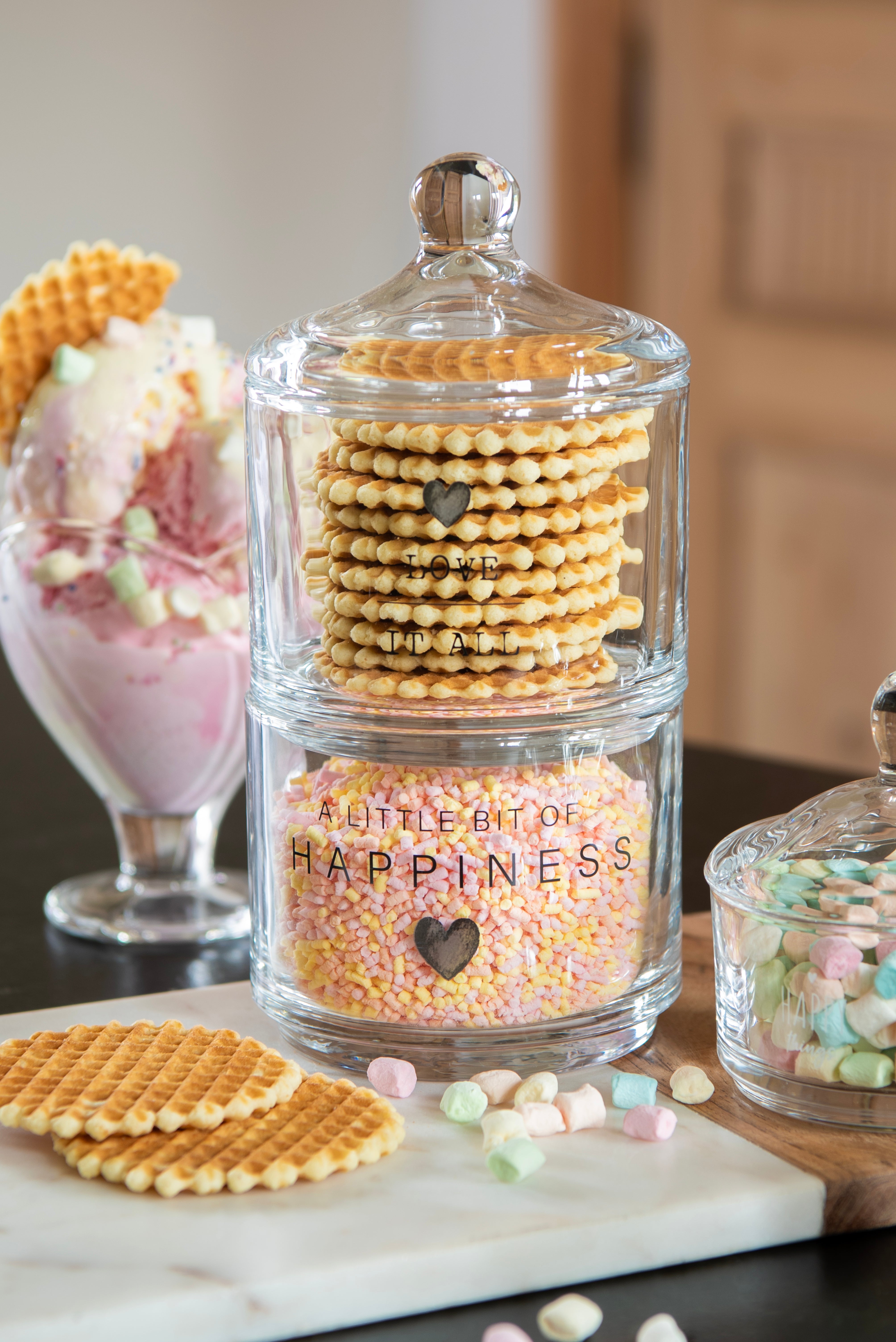 Stacking storage jars from Sable Homeware featuring a cheerful design, used as mugs or jugs for kitchen organization.
