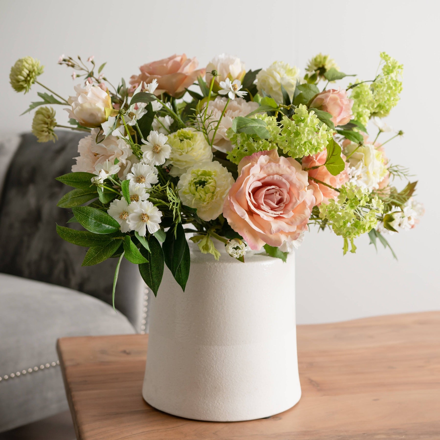 White wash ceramic vase with a smooth, rounded shape and subtle textured finish, ideal for decorative floral displays.