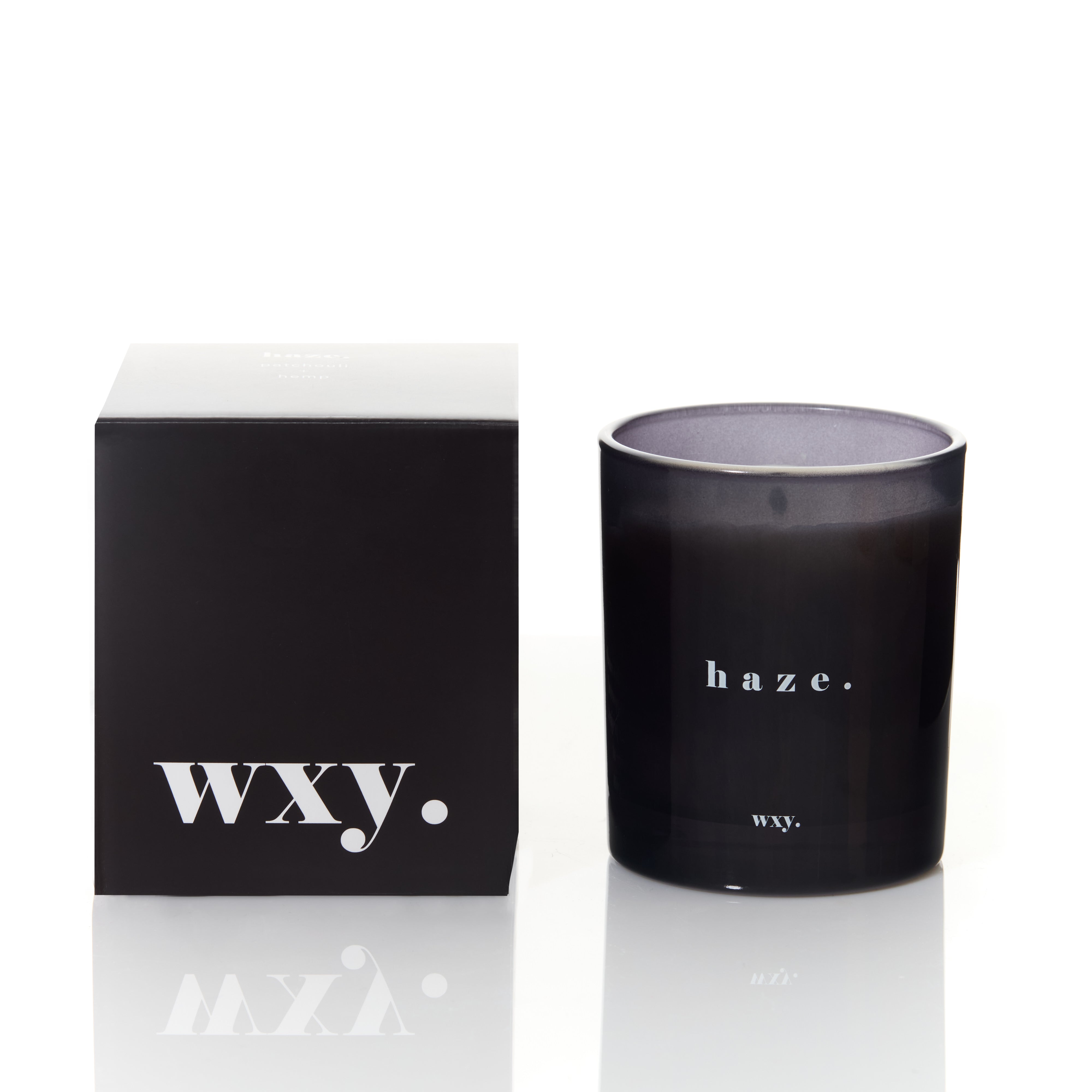 Sable Homeware Haze Patchouli & Hemp Wxy Deluxe Candle with a sleek glass jar and a burning wick, emitting warm, earthy tones.