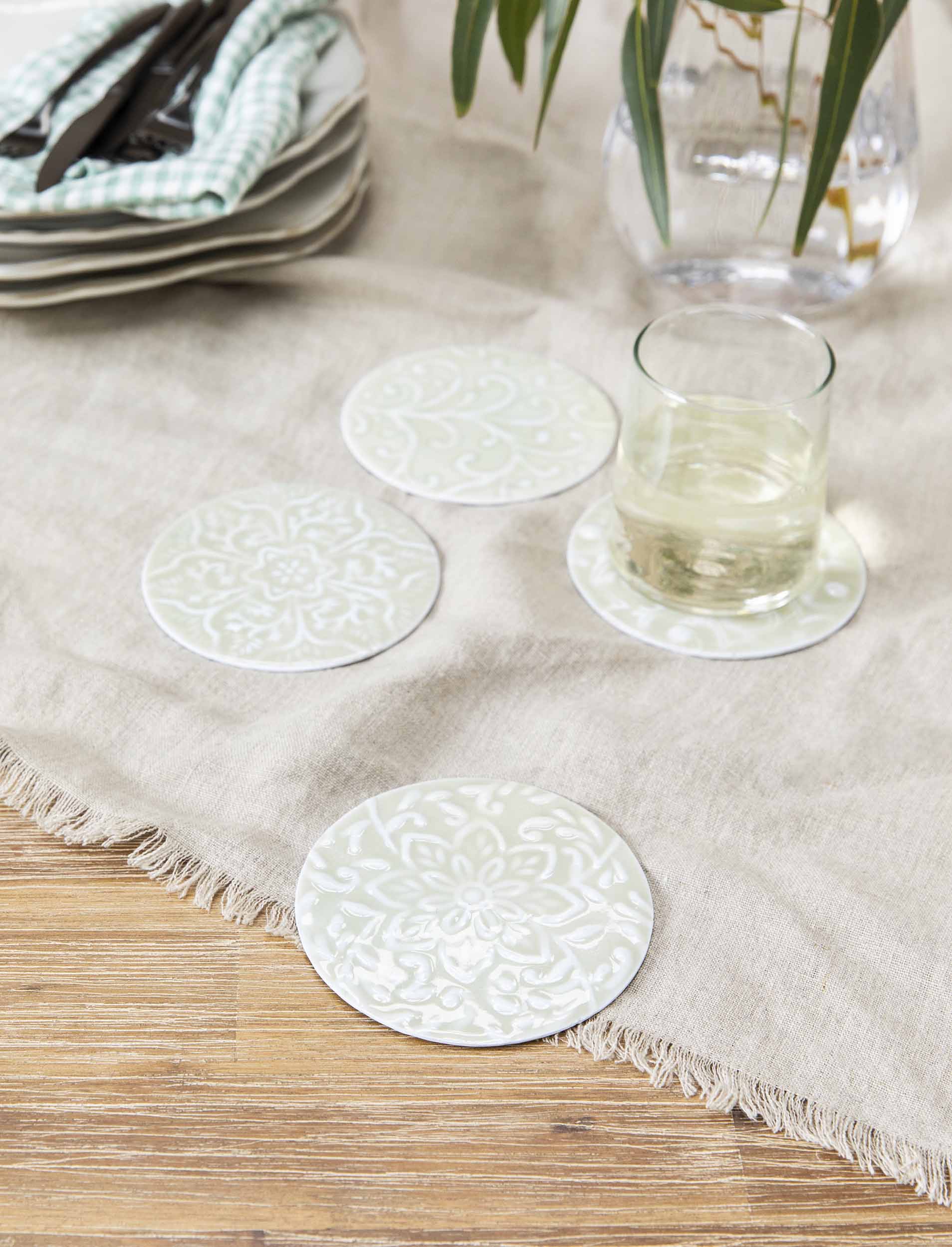 Set of four Fiskardo clay coasters by Sable Homeware, showcasing textured, earthy designs on a neutral surface.