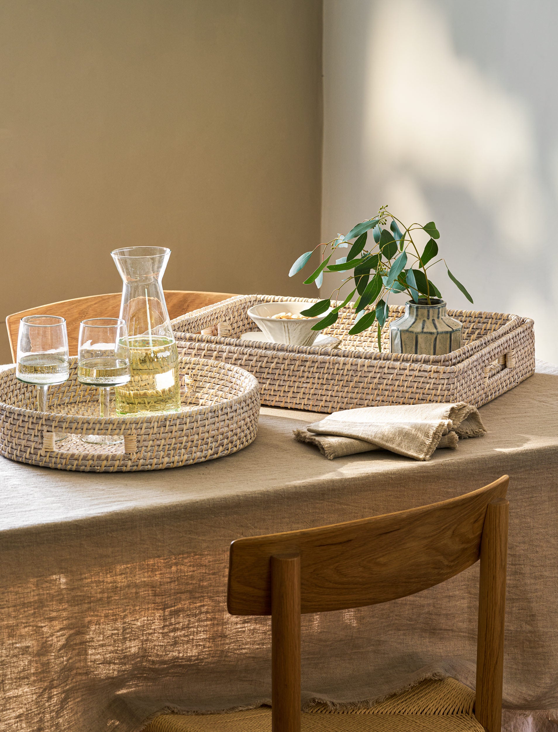 White Wittering Round Rattan Serving Board by Sable Homeware, showcasing a stylish rattan tray on a natural surface.
