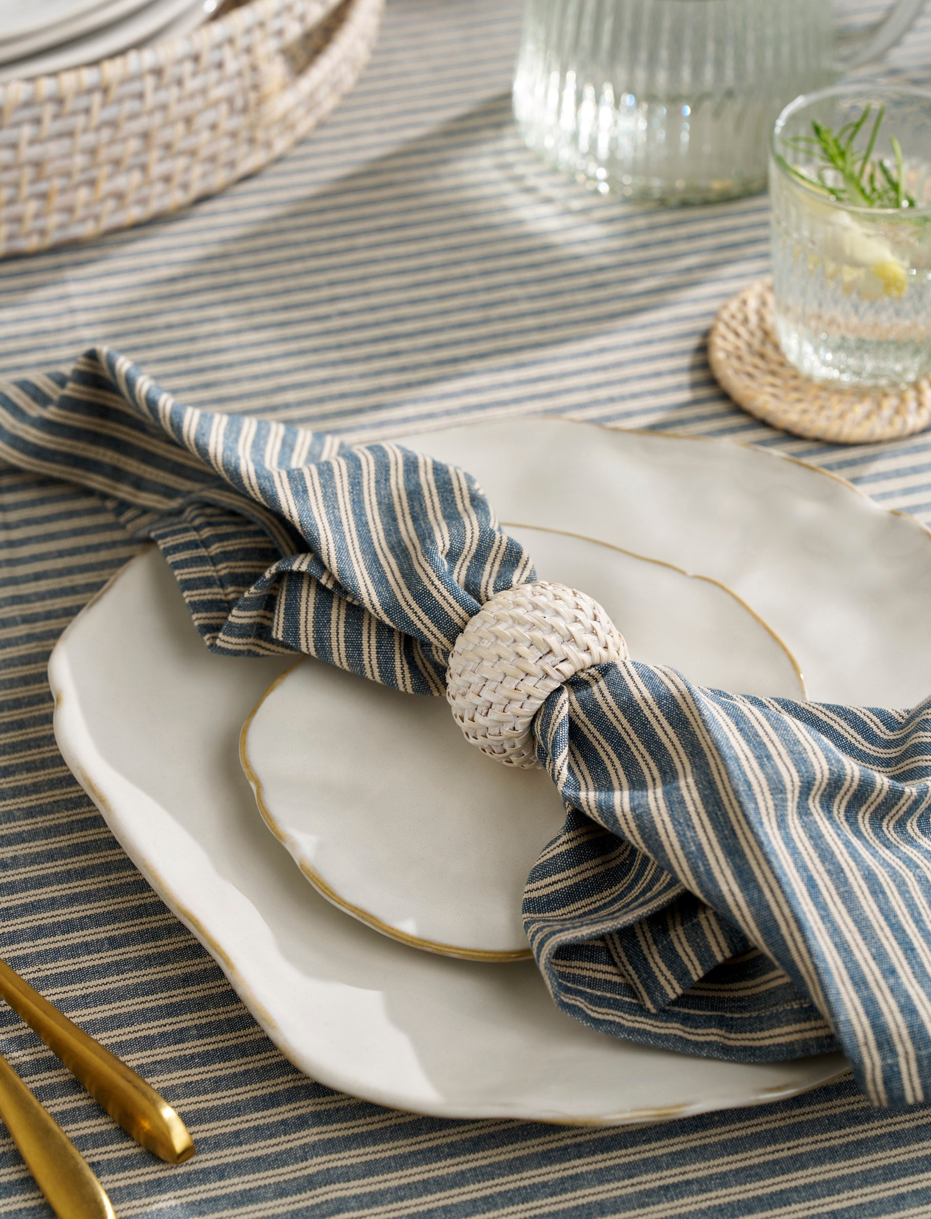 Set of four Wittering rattan white napkin rings from Sable Homeware, showcasing natural woven rattan design for elegant tableware.