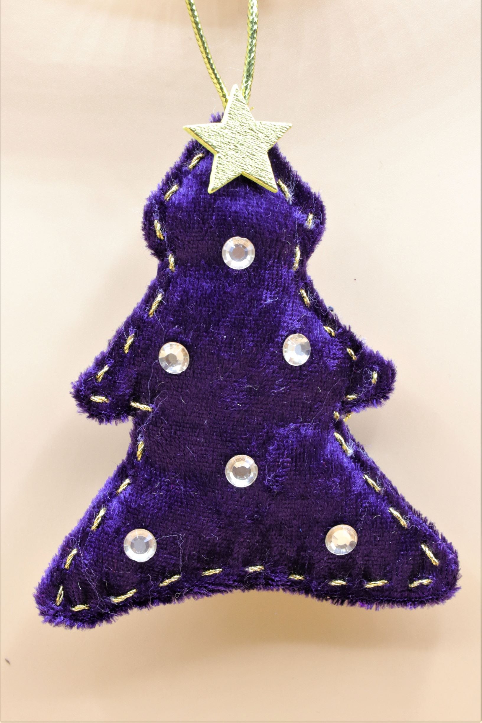 Handmade Sable Homeware Christmas tree ornaments with festive designs hanging on a decorated Christmas tree.