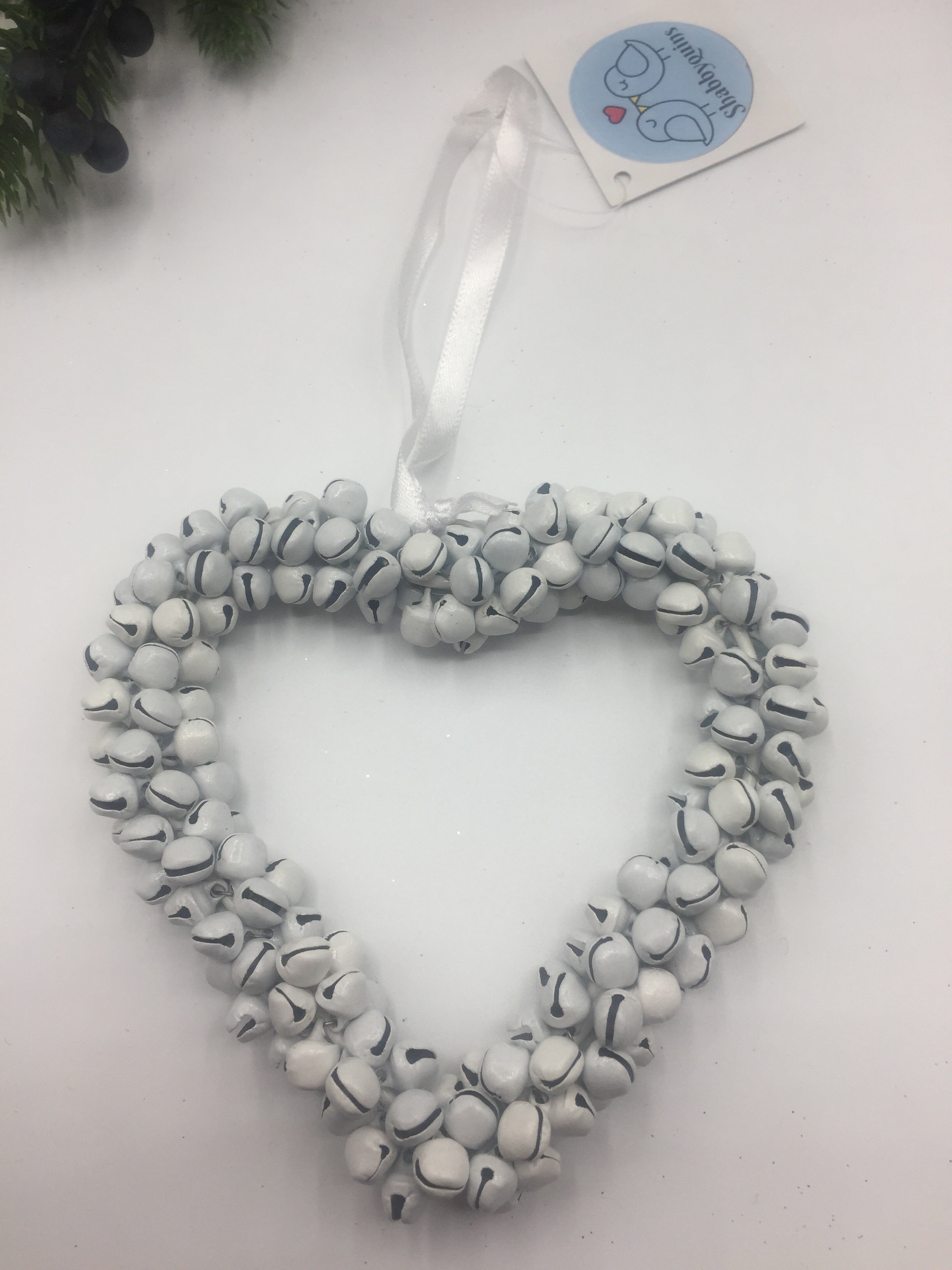 Sable Homeware White Heart Wreath with Bells hanging from a door handle