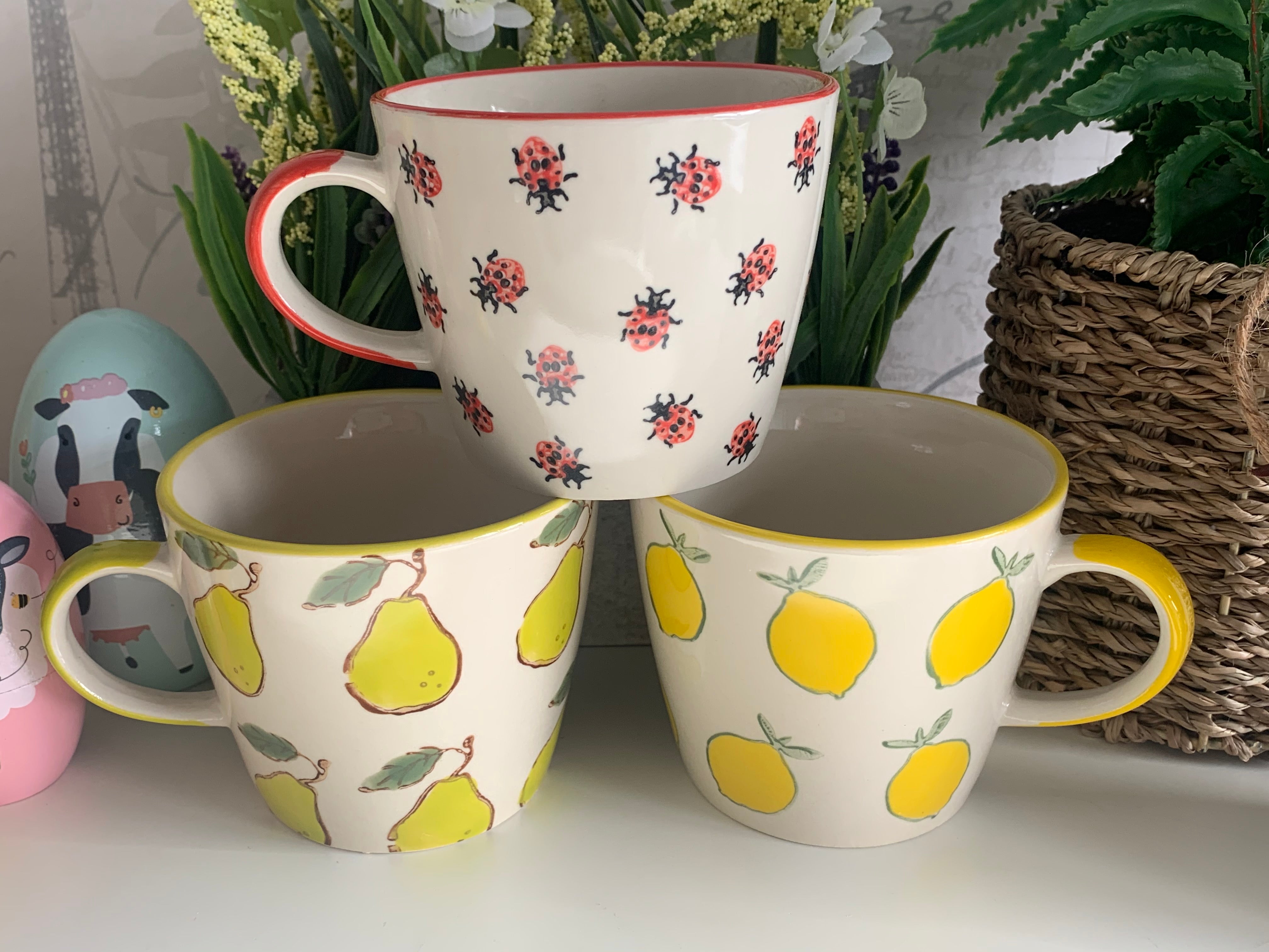 Shabbyquins ceramic mug with various colorful designs, featuring a smooth handle and glossy finish.