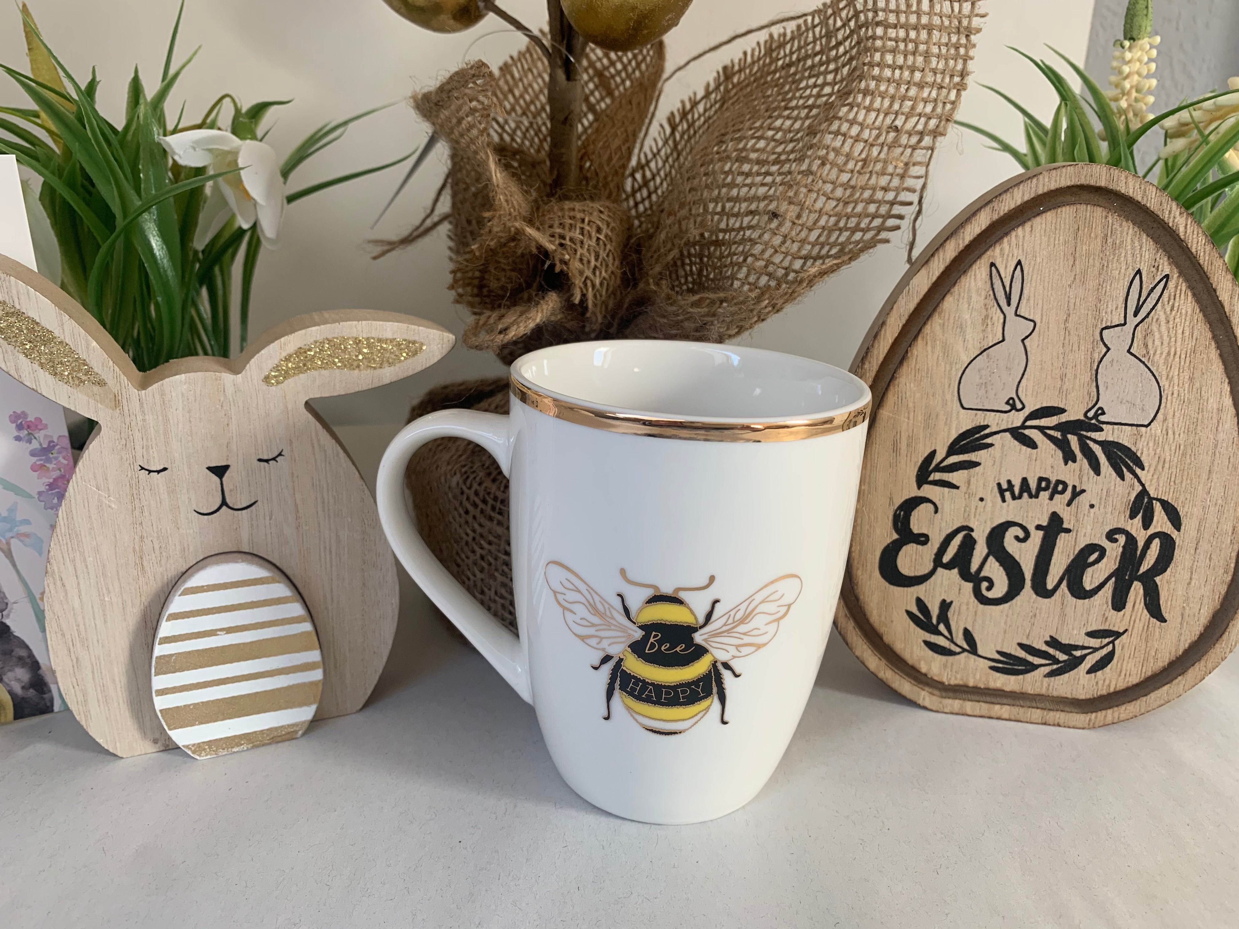 White ceramic mug with gold bee and "Bee Happy" text, showcasing a Shabbyquins mug for tea or coffee.