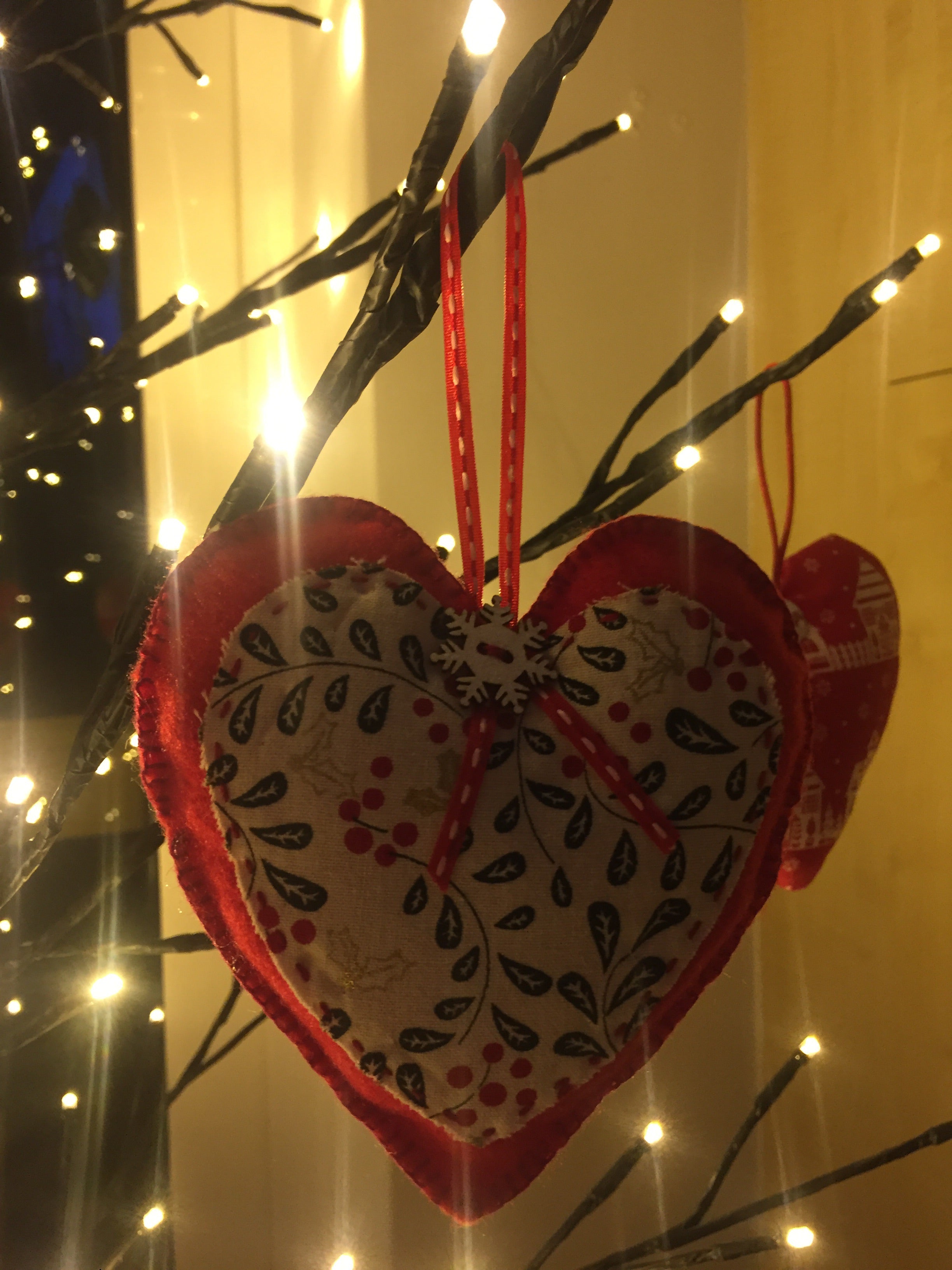 Handmade Christmas tree ornaments from Sable Homeware with festive designs hanging on a decorated Christmas tree.