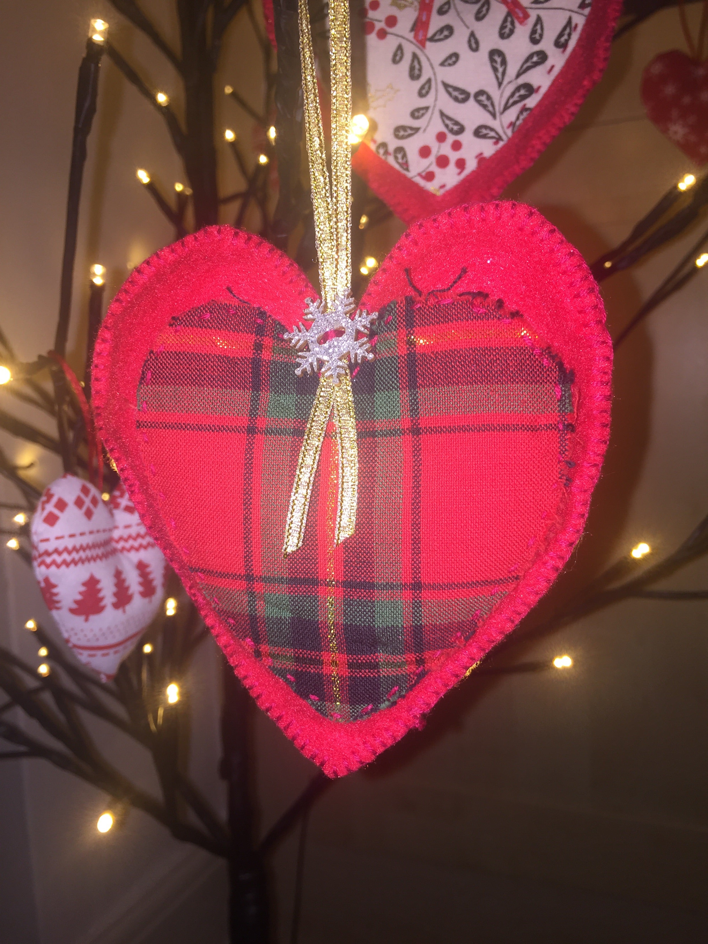 Handmade Christmas Tree Decorations from Sable Homeware, colorful ornaments with festive designs hanging on a decorated Christmas tree.