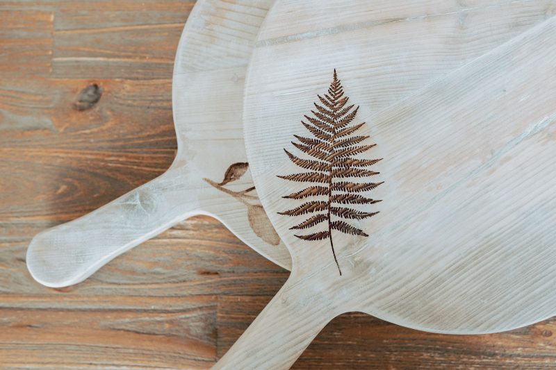 Round Fern & Thistle wooden serving board by Sable Homeware, featuring intricate fern and thistle decorative carvings.