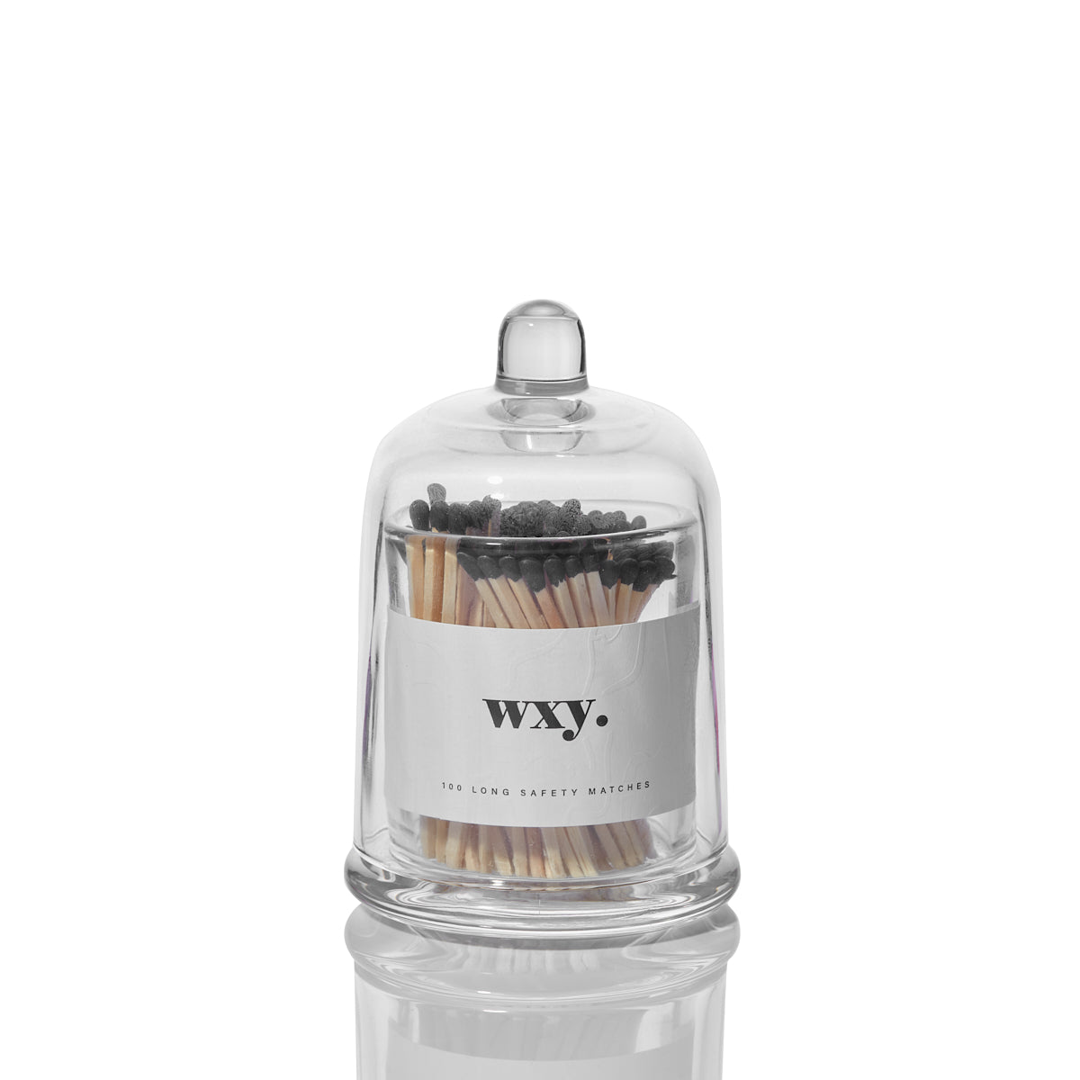 Deluxe Sable Homeware matches inside a glass cloche, displayed on a wooden surface with a modern, stylish decor setting.