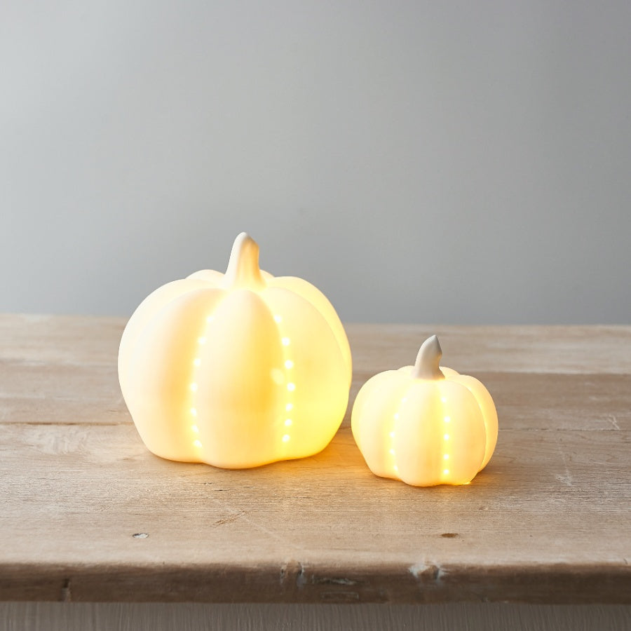 Set of two ceramic LED Halloween pumpkins by Shabbyquins, featuring carved faces and glowing lights for festive décor.
