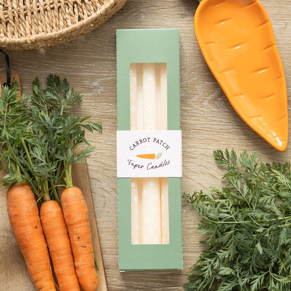 Set of three carrot patch daisy print taper candles by Sable Homeware, with floral and carrot patterns on white wax.