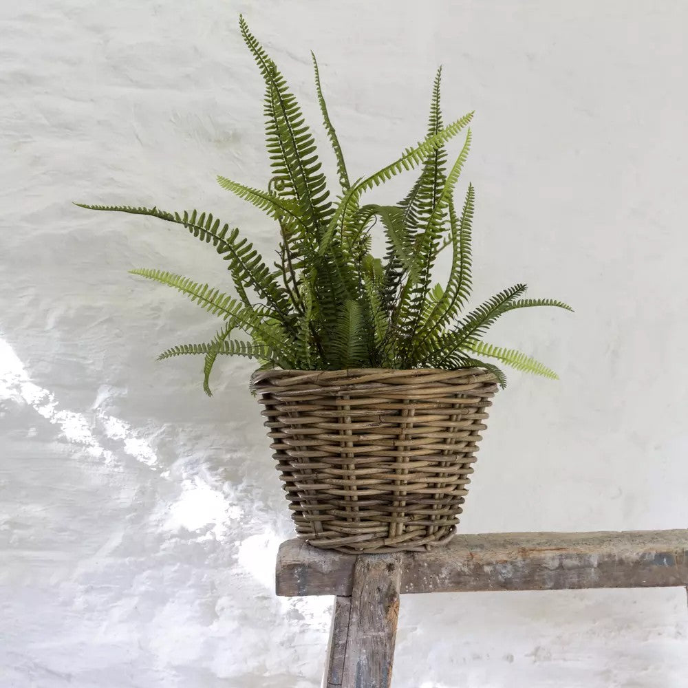 Small grey and buff rattan round wicker planter with a natural woven texture, ideal for indoor or outdoor plant display.