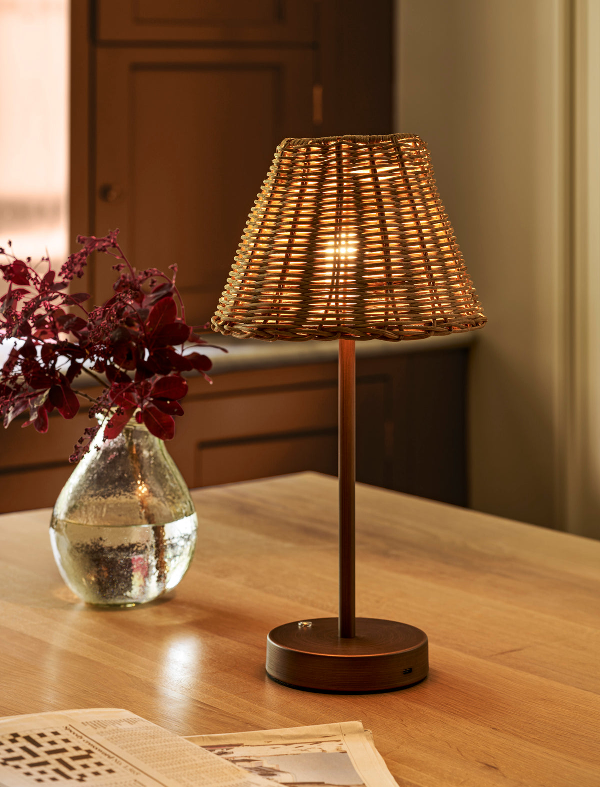 Burleigh rechargeable table lamp with a natural rattan shade and antique bronze iron base