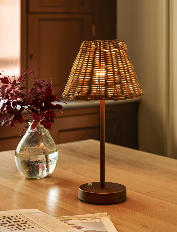 Burleigh rechargeable table lamp with a natural rattan shade and antique bronze iron base