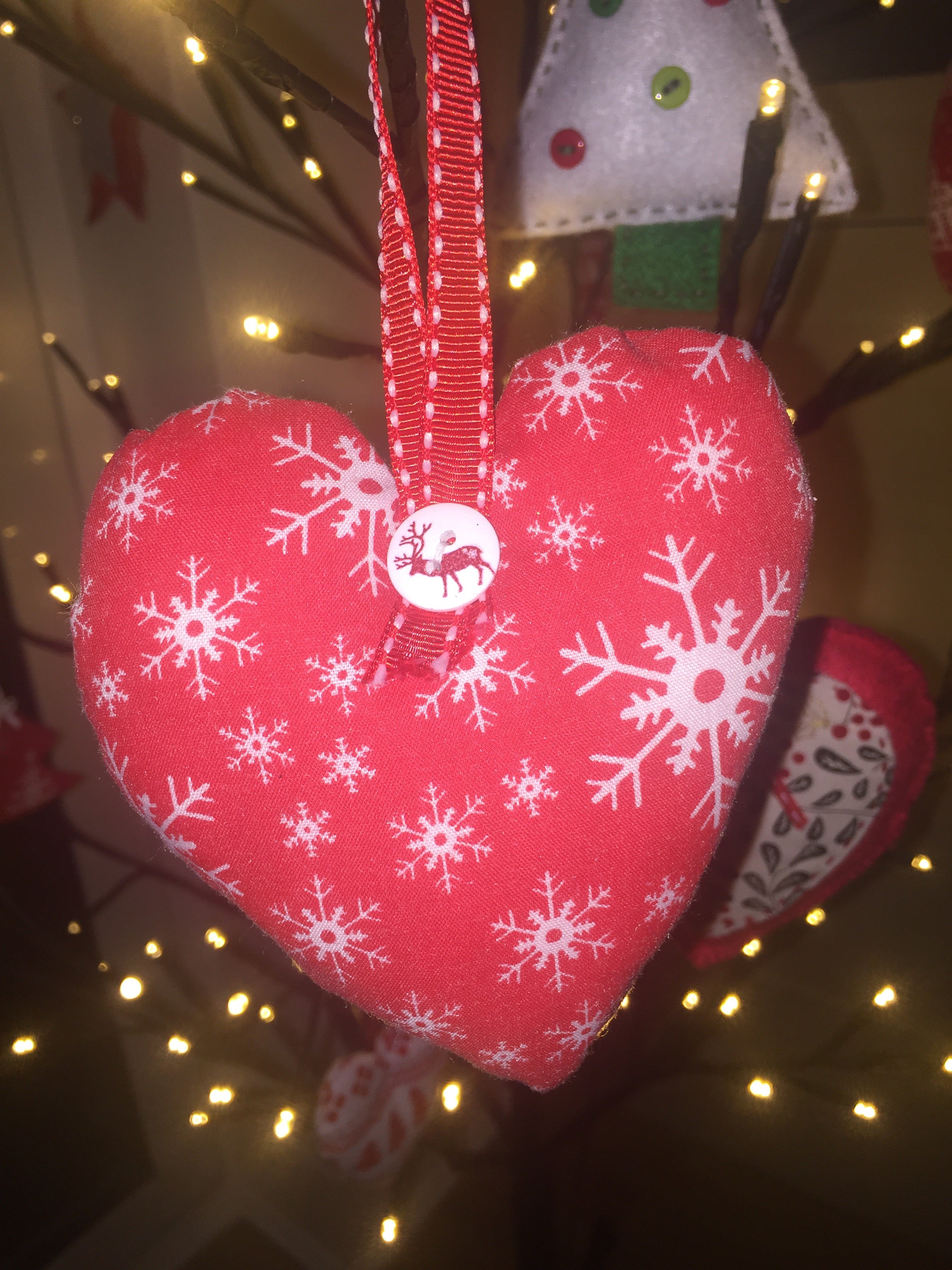Handmade Christmas tree ornaments from Sable Homeware, featuring colorful festive decorations hanging on a decorated Christmas tree.