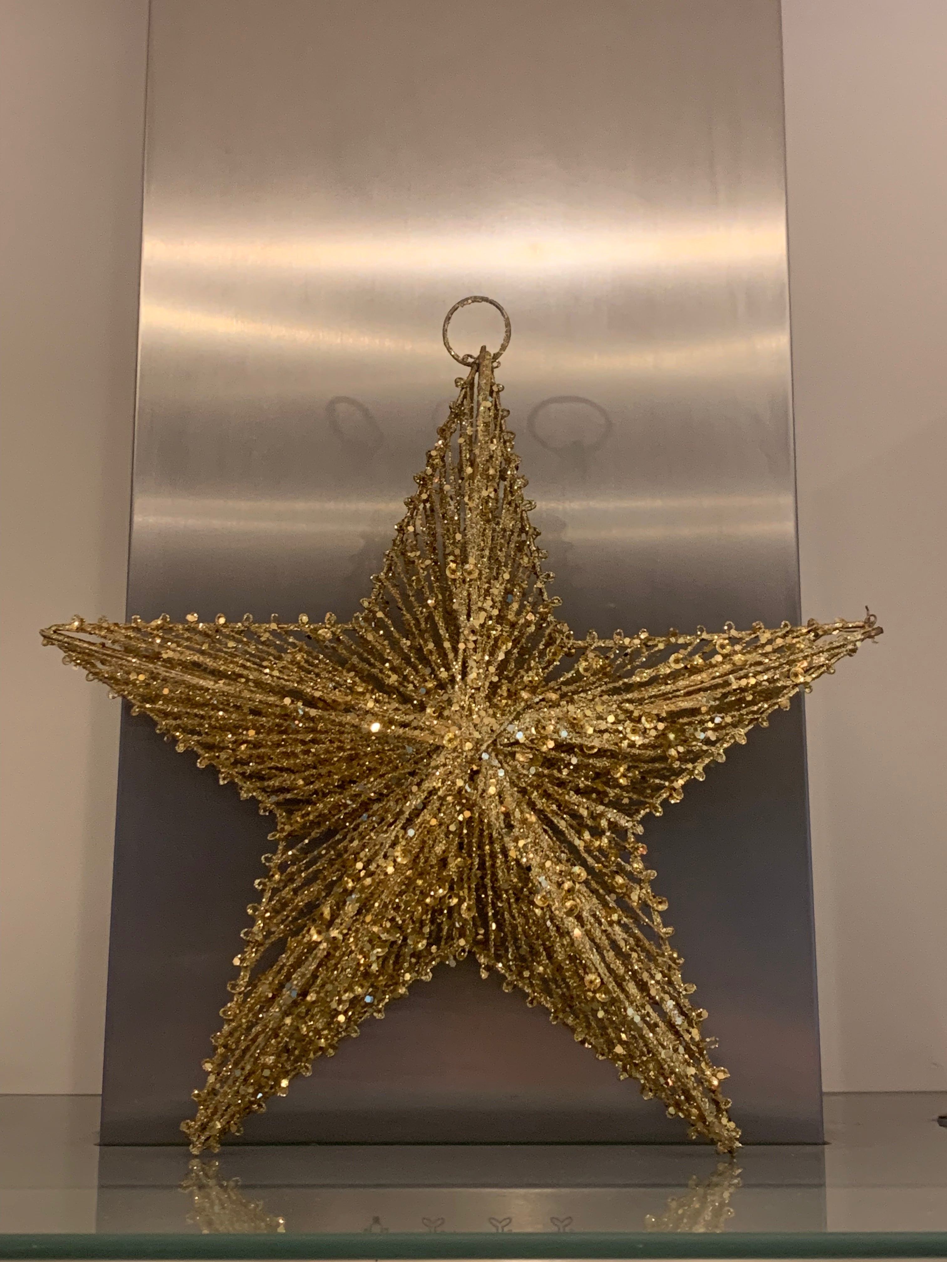 Gold and silver hanging star wreath by Sable Homeware, featuring shimmering metallic stars arranged in a decorative circular design.