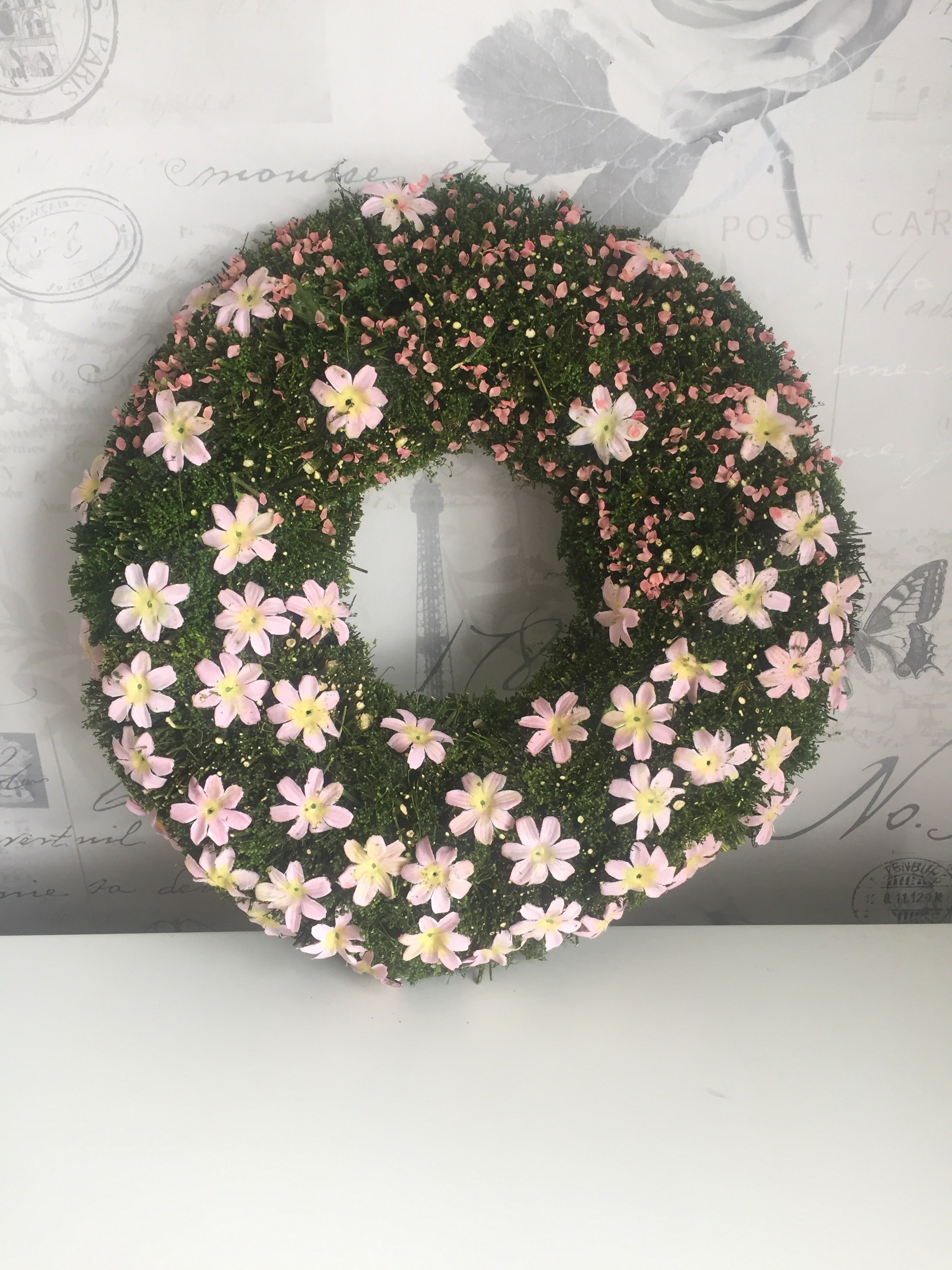 Shabbyquins Easter floral mossy wreath hanging on wall, decorated with spring flowers and greenery for festive decoration